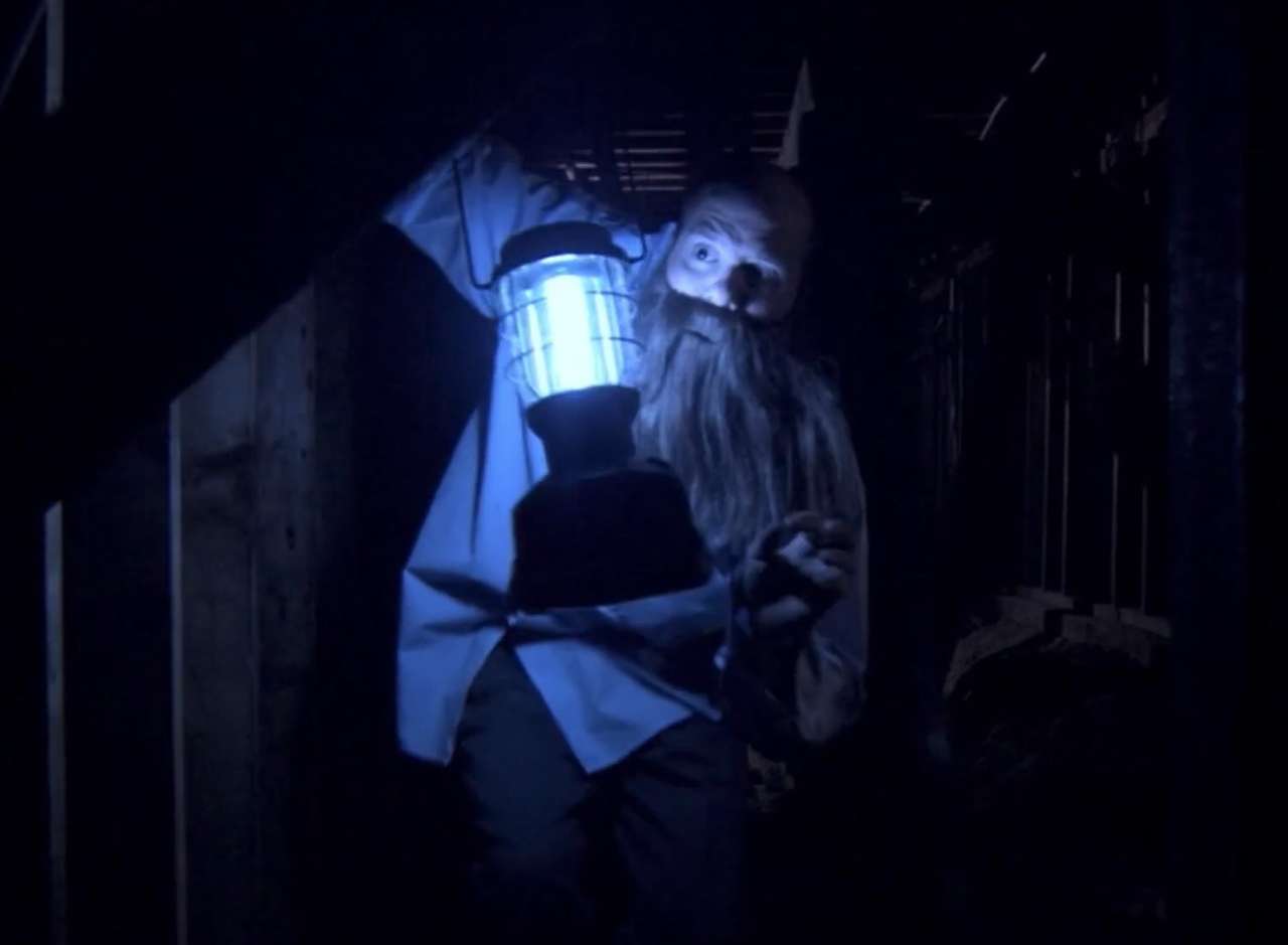 Tobias Funke as George Bluth hiding out in a dark crawl space with a lantern